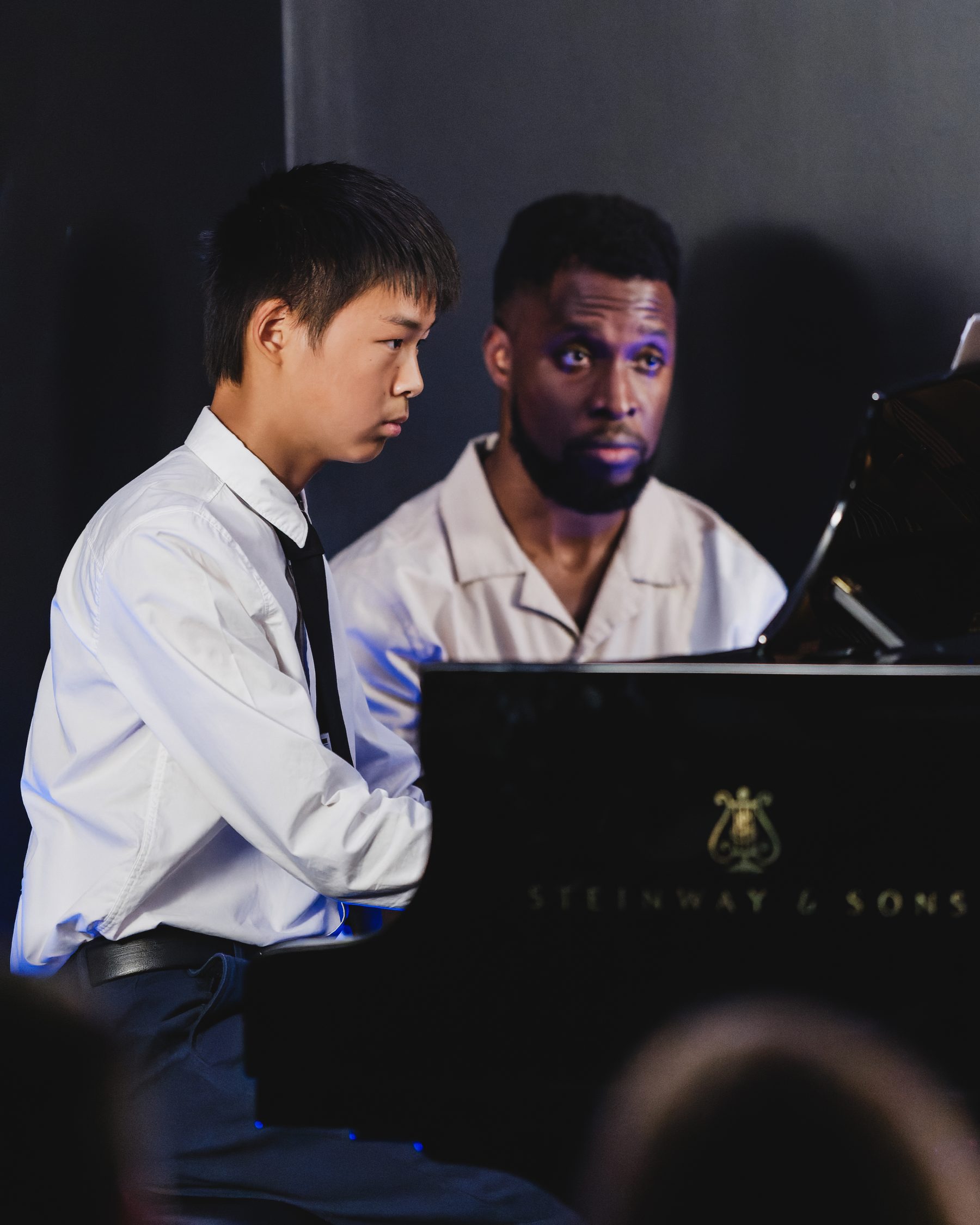 Young student performing piano alongside his teacher in Ottawa